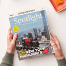 Magazin „Spotlight – Das Magazin zur englischsprachigen Welt“ mit Titelmotiv einer Stadtansicht von New York, im Vordergrund vier sitzende Personen mit Blick auf die Skyline. Sichtbare Schlagzeilen u. a.: „10 amazing places – NEW YORK HIGHLIGHTS“, gelber Kreis „ESSENTIAL TIPS – Never worry about speaking English again“, roter Kreis „We ❤️ NYC – no matter what!“, oben Schriftzug „ZEIT SPRACHEN“ und „ENGLISCH“. Gehalten von zwei Händen über hellem Hintergrund.