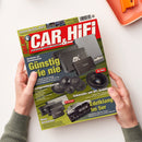 Titelblatt der Zeitschrift „CAR & HIFI“ Ausgabe 4/2025 mit rotem Logo auf weißem Hintergrund. Abgebildet sind mehrere schwarze Auto-HiFi-Geräte, darunter Verstärker, Lautsprecher und Subwoofer der Marken Axton und ASX. Textüberschriften: „Günstig wie nie“, „Lautsprecherparade“, „Neue Verstärker“ und „Edelklang im 5er“. Zwei hellhäutige Hände in grünem Strickärmel halten das Magazin über einer weißen Oberfläche mit orangefarbenem Tablett.