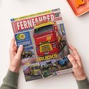 Titelblatt des Magazins „Fernfahrer – Das Truck-Magazin“, Ausgabe 5/2023, gehalten von zwei Händen über hellem Untergrund. Zentral abgebildet ist ein roter Lastwagen mit gelbem Fahrerhaus und der Aufschrift „waldabach-logistik.de“. Textelemente u. a.: „Weltklasse TRUCKS“, „Mobilität der Zukunft“, „Retro Classics Mercedes-Benz“. Weitere kleinere Lkw-Abbildungen in Gelb, Blau und Grün unten im Layout.