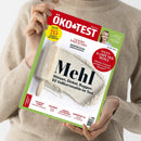 Person in beigem Strickpullover hält das Magazin „ÖKO-TEST“ mit rotem Titelbalken und grünem Rand vor neutralem Hintergrund; auf dem Cover liegt ein hölzernes Nudelholz auf einer Fläche mit ausgestreutem Mehl. Haupttitel: „Mehl – Weizen, Dinkel, Roggen: 50 Vollkornmehle im Test“. Weitere sichtbare Textelemente: „Wettkampf der Mehle“, „Test 215 Produkte“, „April 2024“.