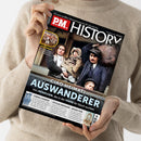 Cover des Magazins „P.M. HISTORY“ mit dem Titel „CIAO HEIMAT! AUSWANDERER – Von MENSCHEN, die in der FERNE ihr Glück suchten“. Im Hauptbild drei erwachsene Personen und ein Kind in historischer Kleidung mit Gepäck auf einem Schiff. Oben links ein gelber Kreis mit dem Text „WATERLOO 1815: Napoleons Niederlage schuf ein neues Europa“. Weitere Überschriften unten: „CHINA-FAHRER“, „STOLZE RIVALEN“ und „SPASS PUR“. Gehalten von einer Person in beigem Pullover.