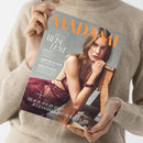 Person in beigefarbenem Strickpullover hält das Magazin „MADAME“ mit orangefarbigem Schriftzug. Auf dem Titel: eine weibliche Person in bordeauxfarbener Spitzenbekleidung, sitzend auf einem hölzernen Stuhl. Sichtbare Textzeilen: „SPECIAL REISE LUST“, „JAPANS SCHÖNSTE GÄRTEN“, „GRIECHENLAND FÜR INSIDER“, „KOPENHAGEN: EUROPAS STIL-METROPOLE“, „BEACH WEAR & ACCESSOIRES MIT OCEAN FLAIR“. Hintergrund neutral grau.