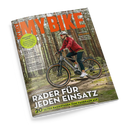 Titelblatt der Zeitschrift „MY BIKE“ mit orangefarbenem Logo im oberen Bereich. Im Vordergrund fährt eine weiblich gelesene Person mit Helm, Sonnenbrille, roter Jacke und schwarzer Hose auf einem grauen E-Bike durch einen lichten Wald. Textaufschriften: „Räder für jeden Einsatz“, „20 Seiten Basiswissen zum Fahrradkauf“, „Citytrip Lissabon“, „Mozart-Radweg“, „Schätze der Vergangenheit“ und „Frühlahrs-Check“.