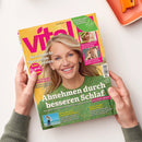 Titelbild der Zeitschrift „vital“ (Ausgabe April/Mai 2024) mit einer lächelnden, hellblonden, weiblich gelesenen Person im grünen Strickpullover vor gelbem Hintergrund. Haupttitel: „Abnehmen durch besseren Schlaf“. Weitere Texte u. a.: „So schmeckt Spargel am besten“, „Bewusst leben, nachhaltig genießen“, „Sonnenschutz für jeden Hauttyp“, „Wie die Schulter wieder rund läuft“. Gehalten von zwei Händen über weißer Fläche mit orangener Schale rechts oben.