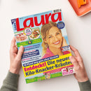 Titelblatt der Zeitschrift „Laura“ mit großer Überschrift in roter Schrift auf hellblauem Hintergrund, im Mittelpunkt ein lächelndes weibliches Model mit blondem Haar und pinker Bluse. Mehrere Textfelder mit Schlagzeilen zu Ernährung, Gesundheit, Haushalt und Lifestyle, darunter „Entdeckt! Die neuen Kilo-Knacker-Kräuter“ sowie Abbildungen von Speisen und Beauty-Produkten; gehalten von zwei Händen über hellem Tischhintergrund.