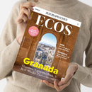 Helle, langärmlig gekleidete Person hält Magazin „ECOS“ aus der Reihe „ZEIT SPRACHEN“ in beiden Händen, Titelmotiv zeigt durch ein maurisch verziertes Steinbogenfenster den Blick auf die Stadt Granada. Aufschrift: „Granada – Alhambra, Tapas und Rock ’n’ Roll: Wo der Zauber nie endet“, zudem spanische Texte: „¡Mejor con salsa!“, „Serie: Un rival para la superheroína“, „Entrevista: Isabel Ajuín y su ‘Potra salvaje’“.
