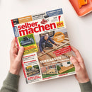 Magazin „selber machen! DIY – Bauen, Gestalten, Renovieren“, gehalten von zwei Händen vor hellem Hintergrund. Titelseite zeigt eine männliche Person beim Bau einer Holzterrasse, dazu gelbe, rote und weiße Textfelder mit Überschriften wie „TERRASSEN-IDEEN selber realisieren“, „LASUREN UND LACKE“, „Innovative Mähroboter“, „Kuschelplätze für Hund und Katze“ sowie kleinere Vorschaubilder zu Holzprojekten und Gartenthemen.
