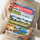 Person in beigem Strickpullover hält die Zeitschrift „CARAVANING – Europas großes Camping-Magazin“ vor neutralem Hintergrund. Auf dem Titelbild sind ein weißer Van, zwei Wohnwagen und eine Blumenwiese vor blauem Himmel zu sehen. Sichtbare Überschriften unter anderem: „Neu! Knaus Nordwind“, „Test LMC Videro 510 E“, „Caravans für Große“, „Kühlen und Lüften“ und „Traumziel Istrien“.