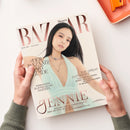 Titelbild der Zeitschrift „Harper’s Bazaar“ mit einer weiblichen Person in einem mintgrünen, tief ausgeschnittenen Kleid und silberner Halskette vor hellem Hintergrund. Sichtbare Schriftzüge: „DER BAZAAR SMART GUIDE“, „THE GREAT OUTDOORS“, „HOSENANZÜGE AUFREGEND ANDERS“ und „JENNIE – EXKLUSIV: DER BLACKPINK-STAR ÜBER IHR SOLO-ALBUM UND SELBSTBEWUSSTEN STYLE“. Gehalten von zwei Händen über hellem Untergrund mit orangefarbener Schale oben rechts.