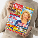 Frau in beigefarbenem Pullover hält das Magazin „mach mal Pause“ (Ausgabe Nr. 22, Mai 2023) in den Händen; Titel zeigt eine lächelnde blonde Frau in blau gemusterter Bluse, Textüberschriften unter anderem „Den Darm sanft stärken“, „So meistert sie den Familien-Wahnsinn“, „Digitale Spar-Helfer“, „106 Traumpreise“, sowie Fotos von Kuchen, Hackgerichten, Getränken und Landschaft.