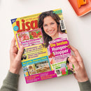 Titelbild der Zeitschrift „Lisa“ mit dem Untertitel „Mit Liebe gemacht“. Im rechten oberen Bereich lächelnde Frau mit braunen Haaren vor hellrosa Hintergrund, links Fotos von Himbeertorte mit der Aufschrift „Kuchenträume mit Himbeeren“. Weitere sichtbare Titel: „Die besten Hunger-Stopper“, „Das große Outdoor-Glück“, „Ist mein Körper intolerant?“, dazu kleinere Textfelder in Pink, Gelb und Blau mit Themen zu Ernährung, Mode und Gesundheit.