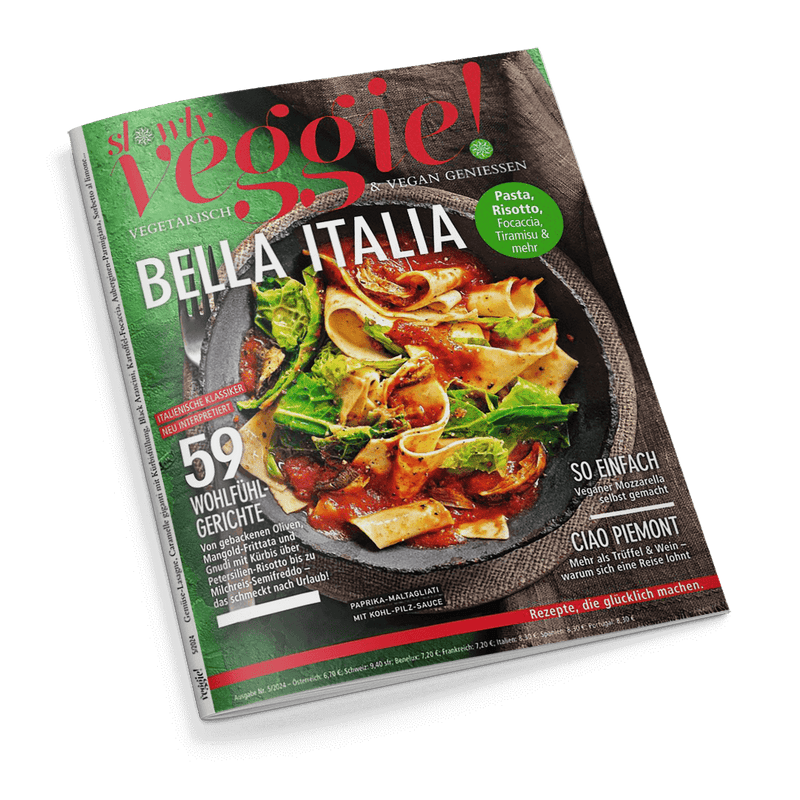 Titelbild der Zeitschrift „slowly veggie! – vegetarisch & vegan genießen“, mit der Ausgabe „BELLA ITALIA“, zentral ein Teller breiter Papardelle mit Tomatensauce, Pilzen und grünem Blattgemüse, umgeben von Texten wie „59 Wohlfühlgerichte“, „Paprika-Maltagliati mit Kohl-Pilz-Sauce“, „Veganer Mozzarella selbst gemacht“ und „Rezepte, die glücklich machen“, grüne runde Aufschrift: „Pasta, Risotto, Focaccia, Tiramisu & mehr“, vor grün-braunem Hintergrund.