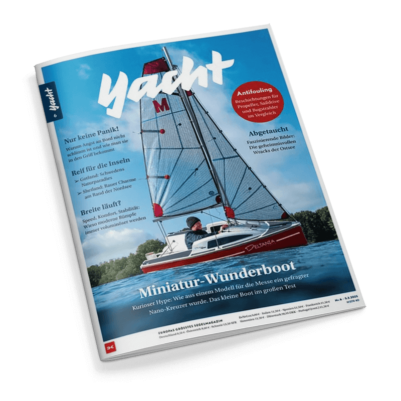 Titelbild der Zeitschrift „Yacht“ mit einem Segelboot auf dem Wasser im Vordergrund, gesteuert von einer männlichen Person; weißes Segel mit rotem „M“, Rumpf in rot-weiß mit der Aufschrift „Delanta“, dominante Himmel- und Wasserfarben, Textinhalte: „Miniatur-Wunderboot“, „Nur keine Panik!“, „Reif für die Inseln“, „Breite läuft?“, „Antifouling“, „Abgetaucht“, Unterzeile: „Europas größtes Segelmagazin“, Ausgabe 6.