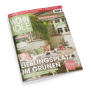 Titelbild der Wohnzeitschrift „WOHNIDEE“ mit grünem Logo und dem Untertitel „Wir lieben unser Zuhause!“. Abgebildet ist eine sommerlich dekorierte Terrasse mit weißem Tisch, grünen und rosafarbenen Kissen, Pflanzen und Blumenranken. Sichtbare Überschriften: „LIEBLINGSPLATZ IM GRÜNEN“, „Gesund schlafen“, „Da blüht uns was!“, „Geflochtene Schönheiten“ und „Wenig Platz, viel Gefühl“.