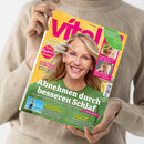 Person in beigefarbenem Strickpullover hält das Magazin „vital“ mit gelbem Titelhintergrund und einer lächelnden, blonden Frau im grünen Pullover auf dem Cover. Sichtbare Schlagzeilen: „Abnehmen durch besseren Schlaf“, „So schmeckt Spargel am besten“, „ADHS, Trauma, Autismus & Co“, „Sonnenschutz für jeden Hauttyp“, „Wie die Schulter wieder rund läuft“ und „Heilsame Orte zum Durchatmen“.