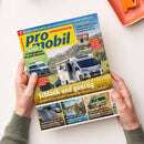 Titelblatt des Reisemobil-Magazins „promobil“, Ausgabe 7, mit gelb-blauem Logo oben links und Titelzeile „Schlank und günstig“ über einem weißen Wohnmobil der Marke Sunlight, das auf einer Wiese steht. Weitere Texte: „14 Campingbusse für große Menschen“, „Solartechnik im Test“, „Westfalia James Cook“, „Relaxen mit Seeblick“. Zwei Hände in grünen Ärmeln halten das Magazin auf hellem Tisch mit orangefarbenem Gegenstand rechts.