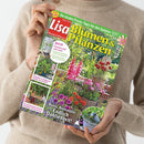Helle, langärmlig gekleidete Person hält das Magazin „Lisa Blumen & Pflanzen“ mit Titelthema „Bunte Blütenfülle – Endlich Dahlienzeit!“ in beiden Händen vor neutralem Hintergrund. Auf dem Cover sind farbenfrohe Gartenpflanzen, Blumentöpfe, ein Tisch mit Gießkanne sowie mehrere kleinere Bildausschnitte mit Garten- und Pflanzmotiven zu sehen, begleitet von Texten wie „Ernteglück im Topfgarten“ und „Für die Pizza-Party: Schnelle Tischdeko mit Geschmack“.