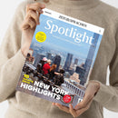 Beige gekleidete Person hält die Zeitschrift „Spotlight – Das Magazin zur englischsprachigen Welt“ mit dem Titelthema „New York Highlights“ vor neutralem Hintergrund; das Cover zeigt vier Menschen auf einer Aussichtsplattform mit Blick auf die Skyline von New York, sichtbare Aufschriften u. a. „10 amazing places“, „Talking to the locals“ und gelber Kreis mit Text „Essential this issue“.