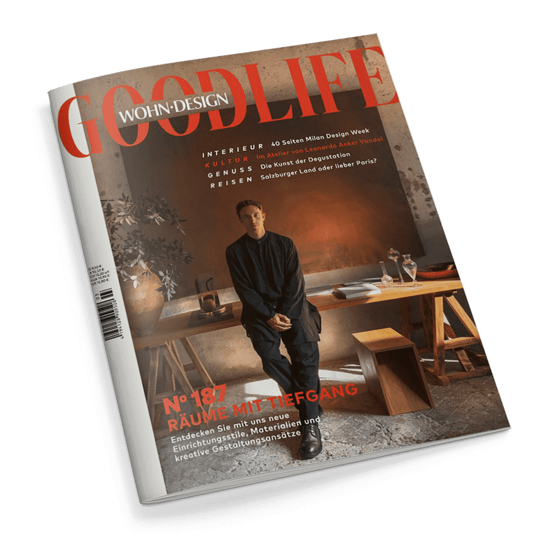 Titelbild der Zeitschrift „GOODLIFE WOHN-DESIGN“, Ausgabe Nr. 187; zentral eine männlich gelesene Person in dunkler Kleidung, sitzend auf einem Holztisch in modernem Interieur mit warmem Licht; sichtbare Überschriften: „RÄUME MIT TIEFGANG“, „40 Seiten Milan Design Week“, „im Atelier von Leonardo Anker Vandal“, „Die Kunst der Degustation“, „Salzburger Land oder lieber Paris?“; im Hintergrund Pflanzen, Bücher, Karaffe und Gläser.