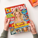 Titelblatt der Zeitschrift „TV DIGITAL XXL“. Im Zentrum eine lächelnde hellblonde Frau vor rotem Hintergrund. Aufschriften u. a.: „Das Beste aus TV, Kino & Streaming“, „XXL AUSGABE“, „Über 100 Sender“, „Plus: Mediatheken-Planer“, „Mission: Impossible“, „Schneller zu den Superhits im Programm“. Das Magazin wird von zwei Händen in grünlichem Pullover auf weißer Fläche gehalten, rechts oben ein orangefarbenes Tablett mit Büroklammern.