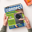 Titelblatt des Technikmagazins „connect“ mit blau-weißem Logo und weißer Unterzeile „Die Test-Instanz für Smartphones“. Auf grünem Hintergrund ist ein großer Smartphone-Kameraausschnitt mit „Leica“-Logo abgebildet. Textausschnitte: „Leica Leitzphone – Beste Smartphone-Kamera“, „WM-Spezial“, „Viel Technik, kleiner Preis“, „Besser als Apple“. Zwei Hände in grünen Ärmeln halten das Heft über hellem Tisch, daneben orange Ablage.