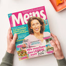 Frauenzeitschrift „Meins“ mit pinkem Titelkopf auf türkisfarbenem Hintergrund, mittig eine lächelnde Frau mit braunen, schulterlangen Locken in rosafarbenem Oberteil. Schlagzeilen u. a.: „TOP-WUNDER-GRIFFE gegen Verspannungen“, „Wir machen das LEBEN zum Fest!“, „Adele Neuhauser (66) – Zeit für neue Abenteuer“. Abgebildet sind außerdem Fotos von Speisen, Dekoideen und einer Stadtansicht von Wien. Gehalten von zwei Händen über beiger Oberfläche.