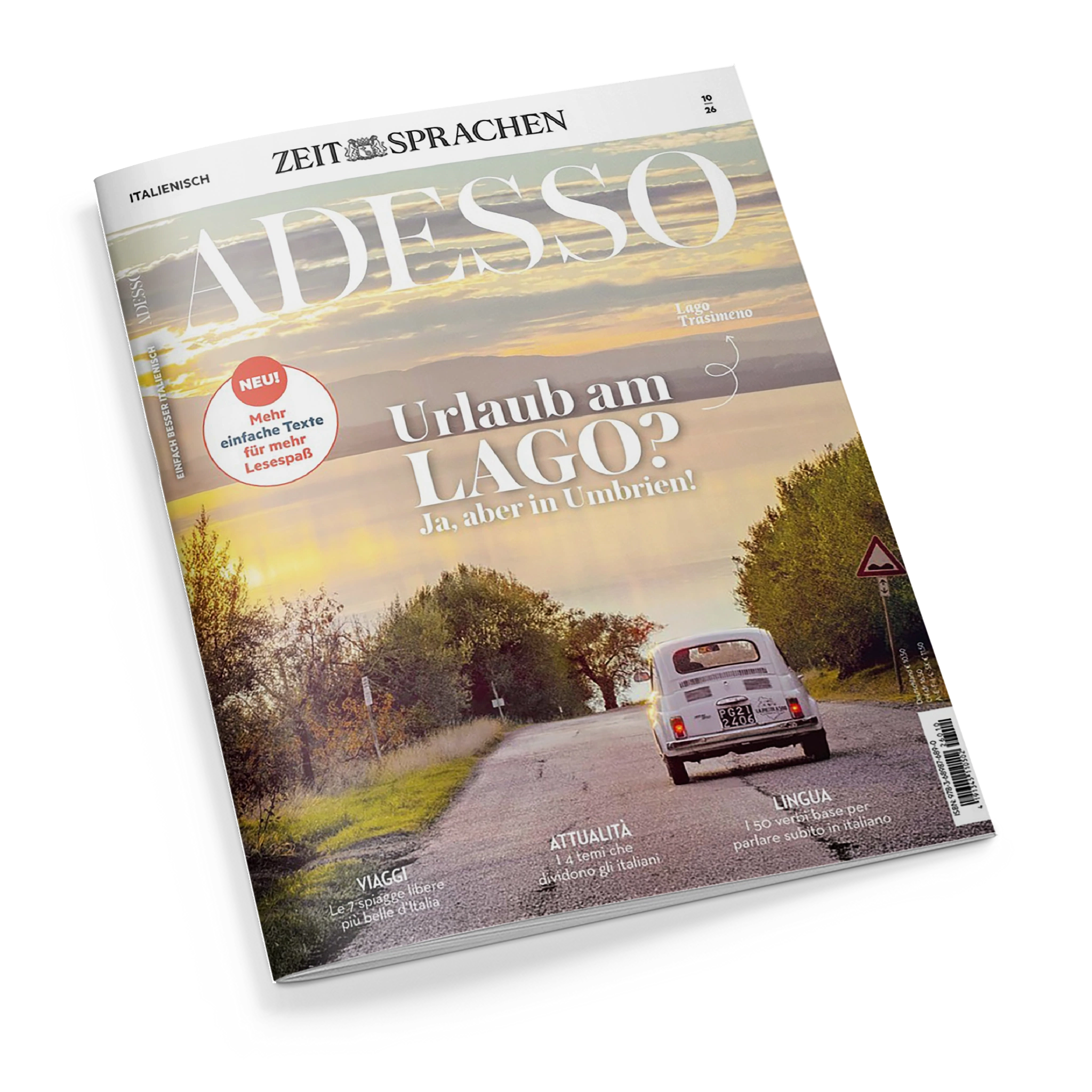 Schräg fotografiertes Magazincover aus Papier mit dem Titel „ZEIT SPRACHEN – ITALIENISCH: ADESSO“ und der Aufschrift „Urlaub am LAGO? Ja, aber in Umbrien!“, Hinweis „Lago Trasimeno“ sowie rotem Kreis „NEU! Mehr einfache Texte für mehr Lesespaß“. Das Titelbild zeigt eine Straße mit weißem Kleinwagen, Bäumen, Verkehrsschild und bewölktem Himmel; unten stehen „VIAGGI“, „ATTUALITÀ“ und „LINGUA“.