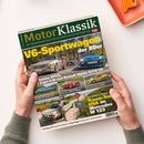 Titelblatt der Zeitschrift „Motor Klassik“ mit dem Haupttitel „V6-Sportwagen der 80er“ in gelber Schrift. Oberhalb grün-weißes Logo „MotorKlassik“. Zu sehen sind mehrere klassische Autos, u. a. Alfa Romeo GTV6, Ford Capri 2.8i, Renault Alpine A310 V6, Porsche 911 Carrera 3.2, Maserati A6GCS Spyder und Renault Sport Spider. Unten ein weißer Mercedes W123 neben einer Person, Hintergrund mit Straße und Herbstbäumen.