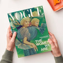 Titelbild der Zeitschrift „Vogue Deutschland – Collector’s Issue“ mit einer blonden, weiblich gelesenen Person in gemustertem blau-grünem Kleid vor kaleidoskopartigem Hintergrund. Aufschrift: „EIN KALEIDOSKOP DES FRAUSEINS“, „THE WOMEN WE ARE“ und „MALA EMDE“. Gehalten von zwei Händen vor hellem Untergrund mit orangefarbenem Tablett am oberen Bildrand.