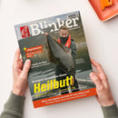 Schräg fotografierte Zeitschrift „Blinker“, gehalten von zwei Händen vor weißem Hintergrund; auf dem Titel hält eine männliche Person einen großen dunklen Heilbutt vor einer Landschaft. Sichtbare Texte: „Fliegenfischen“, „Bachforelle ‚trocken‘ fangen“, „Hotspots im Fluss“, „Norwegens spannendster Räuber“, „Heilbutt“, „Spinnfischen Light“, „Naturköder Light“ und „Wieso mm-Angaben bei Geflecht reine Fiktion sind“.