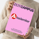 Person in beigem Strickpullover hält ein Magazin mit rosafarbener Titelseite in beiden Händen. Oben steht in schwarzer und dunkelblauer Schrift „ZEIT CAMPUS“, mittig das rote Kreislogo mit weißem Dreieck und der Schriftzug „Akademiker“, unten in kleiner schwarzer Schrift der Text: „Noch nie waren so viele junge Menschen nach dem Studium arbeitslos. Wie du trotzdem deinen Weg findest.“