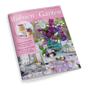 Titelbild der Zeitschrift „Wohnen & Garten“ Februar 2025 mit rosafarbenem Rand und floralen Motiven; zentrale Abbildung eines lila-weiß gemischten Blumenstraußes in glasgrüner Vase, begleitet von den Texten „Zauberhafte Frühlingsgrüße“ und „Verliebt in duftige Zierkirschen“, weitere Textbeiträge: „Kreativ verwandelt – Romantische Accessoires mit weißer Spitze“, „Frischer Wind im Bad – Schnelle Ideen für ein neues Raumgefühl“, „Ein Traumhaus im edlen Country-Look“.