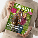Beige gekleidete Person hält ein schräg fotografiertes CAVALLO-Reitsportmagazin mit grünem Titelbild: braunes Pferd mit weißer Stirnzeichnung und weibliche Reiterin in burgunderrotem Oberteil. Lesbare Texte: „PROFI-TIPPS FÜR STARKE SEHNEN“, „Sportliches Vorbild“, „Das steckt im Mash“ und „Reitunterricht neu gedacht“.