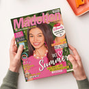 Titelblatt der Jugendzeitschrift „Mädchen“ mit einer lächelnden weiblichen Person in pinkem Oberteil, rosa Perlenkette und glatten braunen Haaren vor grünem Hintergrund. Sichtbare Texte: „Wir feiern 50 Jahre“, „K-Beauty – Mega-Hype aus Korea“, „Dein Ferienflirt“, „We ♥ Summer“, „Trendy Schmuck-Set“, „Foto-Fun mit der BFF“. In der linken Hand werden bunte Armbänder gezeigt, auf dem Cover sind auch zwei Poster-Extras abgebildet.