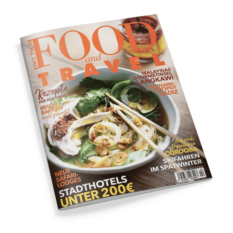 Titelbild der deutschsprachigen Zeitschrift „Food and Travel“, mittig eine Schüssel mit asiatischer Nudelsuppe, dekoriert mit Kräutern, Frühlingszwiebeln und Chili, darüber zwei helle Essstäbchen; Überschriften u. a.: „Rezepte für den Frühling“, „Irisch backen leicht gemacht“, „Stadthotels unter 200 €“, „Malaysias Gourmetinsel Langkawi“, „Kulinarik-Hotspot Cádiz“, „Skifahren im Spätwinter“, „Neue Safari-Lodges“ und „Cordoba – Auf nach Argentinien“.