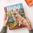 Titelblatt des Magazins „Partner Hund“ (Ausgabe Juni 6/2025) mit einem hellbraun-weißen Hund mit angeleintem Halsband, der auf einem Holzsteg vor Wasser sitzt. Um ihn herum farbige Überschriften wie „Lass die anderen reden“, „Tolles Training“, „Gesundheit“, „Reisereportage Traumziel Lago Maggiore“ und Hinweis auf „16 Seiten EXTRA“. Zwei Hände halten das Magazin vor hellem Hintergrund.