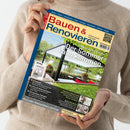 Person in beigem Strickpullover hält eine Ausgabe des Magazins „Bauen & Renovieren“ mit gelb-blauem Titelkopf. Auf dem Cover ist eine überdachte Terrasse mit Blick auf einen See und grüne Bäume abgebildet, mit dem Hauptschriftzug „Der Sommer kann kommen“. Weitere sichtbare Texte nennen Themen wie „Innenräumen“, „Luft-Luft-Wärmepumpen“, „Feuchtes Mauerwerk“, „Balkonterrasse“ und das Extra „smart living“.