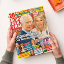 Aufgeschlagene Zeitschrift „Echo der Frau“ in schräger Aufsicht, von zwei Händen gehalten. Das farbige Cover zeigt einen älteren Mann mit weißem Haar und eine blonde Frau sowie weitere kleinere Porträts; sichtbare Texte sind „20 Seiten SUPER RÄTESPASS“, „Bargeld zu gewinnen“, „Mit RÄTE-KRIMI“, „Aufregung vor dem großen Tag“, „ABDRANKUNG! Der Termin steht fest“, „William & Kate“, „Pikante Gerichte in Monaco“ und „NEU!“.