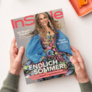Titelbild der Zeitschrift „InStyle“, gehalten von zwei Händen vor hellem Hintergrund. Abgebildet ist eine lächelnde weibliche Person mit langen, welligen Haaren in einem bunten, geblümten Kleid mit blauem Puffärmel-Überwurf. Überschriften auf dem Cover: „60 Wow!-Kleider“, „Time to Shine“, „ENDLICH SOMMER!“, „Flirty Fransen-Pieces“, „Trendfarbe Buttergelb“, „Heiße Schnür-Sandalen“, „Accessoires in Sorbet“.
