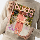 Person in beigem Strickpullover hält ein Magazin mit dem Titel „burda style“ in Rosa-Lila-Tönen. Auf dem Cover: weiblich gelesene Person in roséfarbenem Kleid, Strohhut und Sonnenbrille vor grün-blühendem Hintergrund. Sichtbare Texte: „La Dolce Vita“, „Exklusive Männerschnitte“, „Sporty oder Couture?“, Hinweis auf „75 Jahre Burda style“ und Webadresse „burdastyle.de“.