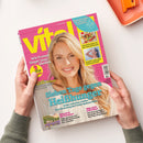 Titelbild der Zeitschrift „vital“ mit einer blondhaarigen lächelnden Frau vor pinkem Hintergrund. Textelemente: „Wie Frauen länger jung bleiben“, „Sieben Tage gegen Heißhunger“, „Genussrezepte für den Sommerabend“, „So geht optimales Haarewaschen“, „Retreat in der Provence“ und „Bitte nicht still leiden“. Oben rechts blaues Feld mit Aufschrift „Bewusst leben, nachhaltig genießen“. Zwei Hände halten die Ausgabe.