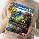 Weibliche Person im hellbeigen Strickpullover hält eine schräg ausgerichtete, farbige Gamingzeitschrift mit beiden Händen. Auf dem blauen Cover stehen „Gamesstar“, „Palworld • SOKO 1977 • Guns of Eschaton • Kinstrife • Dawn of Piracy • Mortal Shell“ und „CORSAIR COVE“; abgebildet sind ein Pirat, Palmen und Meer sowie die Beiträge „THE BLOOD OF DAWNWALKER“ und „ASSASSIN’S CREED: BLACK FLAG RESYNCED“.
