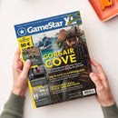 Aufgeschlagenes GameStar-Magazin mit blauem Titelbereich, gelber Seitenleiste und Covermotiv eines männlichen Piraten vor Karibiklandschaft mit Schiff und Palmen. Lesbare Texte: „GameStar“, „CORSAIR COVE“, „THE BLOOD OF DAWNWALKER“, „ASSASSIN’S CREED: BLACK FLAG RESYNCED“, „REGIONS OF RUIN“ und „AFTERLOVE EP“; das Magazin wird von zwei Händen über einem weißen Tisch gehalten.