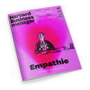 Schräg liegendes Magazincover von „Harvard Business Manager“ mit pink-violettem Farbverlauf, schwarzer Typografie und gezeichneter männlicher Person im Anzug, die ein Herz mit den Händen formt. Sichtbare Texte: „Empathie – Die Superkraft in der Krise“, „Das Wissen der Besten“, „Preissenkungen“, „Stakeholder“, „Einstiegsjobs“, „Überlastung“ sowie „HBM“.