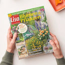 Schräg fotografierte Zeitschrift „Lisa Blumen & Pflanzen“ mit grünem Titelbalken, gelber Überschrift „Blumen & Pflanzen“ und Gartenszene mit violetten, weißen, gelben und rosafarbenen Blüten. Sichtbare Texte: „Praxis-Tipps für Balkon und Garten“, „Herbst-Anemonen – die schönsten Sorten“, „Neue Pflanz-Ideen: Blütenreicher Spätsommer“ sowie Hinweise zu Tischdeko, DIY-Projekten und Balkongestaltung; zwei Hände halten das Heft.