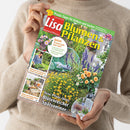 Eine Person im beigefarbenen Strickpullover hält ein schräg ausgerichtetes Gartenmagazin mit dem Titel „Lisa Blumen & Pflanzen“ und der Aufschrift „Praxis-Tipps für Balkon und Garten“. Das Cover zeigt Blumenbeete, Balkonpflanzen, Gartenmöbel und eine Gärtnerin; weitere Texte lauten „Neue Pflanz-Ideen“, „Blütenreicher Spätsommer“, „Blattsalate für den Herbst anbauen und genießen“ und „Balkon und Terrasse einfach kreativ umgestalten“.