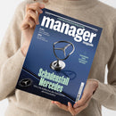 Person im cremefarbenen Strickpullover hält ein schräg fotografiertes, dunkelblaues Magazin mit dem Titel „manager magazin“. Sichtbare Texte: „AUGUST 2026“, „RÜSTUNGS-ETFs: Wo sich der Einstieg noch lohnt“, „KI-DUELL: Wie Anthropic OpenAI überholt“, „QIAGEN: Der Biotech-Pionier stürzt ab“, „Schadenstall Mercedes“ und „Wie Ola Källenius die Edelmarke abwirtschaftet“; darunter ein Mercedes-Benz-Logo.
