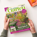 Schräg gehaltenes Gartenmagazin „mein schöner Garten“ mit grünem Titel auf weißem Hintergrund, Ausgabe „September 2026“ und Titelzeile „Europas größtes Gartenmagazin“. Das Cover zeigt einen blühenden Garten, zwei Hände mit grauen Ärmeln, den Text „Klimaschutz + Artenvielfalt – Kein Garten ohne Hecke“, „Blütenglück mit pflegeleichten Fetthennen“ sowie ein Bild mit „Zucchini & Kürbis – Beet auf den Tisch“; oben rechts liegt ein oranges Tablett.