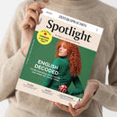 Von zwei Händen gehaltenes Magazin „Spotlight“ von ZEIT SPRACHEN mit beigefarbenem und grünem Cover. Darauf eine weibliche Person mit langem, lockigem, rotem Haar und grünem Oberteil, die einen Ball mit Union-Jack-Muster hält, sowie die Texte „ENGLISCH“, „English Decoded“, „THE BIG REPORT: CANADA A BETTER USA?“, „Sri Lanka“, „The Blues“ und „Milk-Float Memories“.