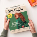 Schräg auf einer hellen Fläche gehaltenes Magazin „Spotlight“ von „ZEIT SPRACHEN“ mit cremefarbenem und grünem Cover; darauf eine Frau mit lockigem roten Haar und grünem Oberteil. Sichtbare Texte: „ENGLISCH“, „Das Magazin zur englischsprachigen Welt“, „ENGLISH DECODED“, „Understanding what we say – and what we really mean“, „CANADA A BETTER USA?“, „SRI LANKA“, „THE BLUES“ und „MILK-FLOAT MEMORIES“.